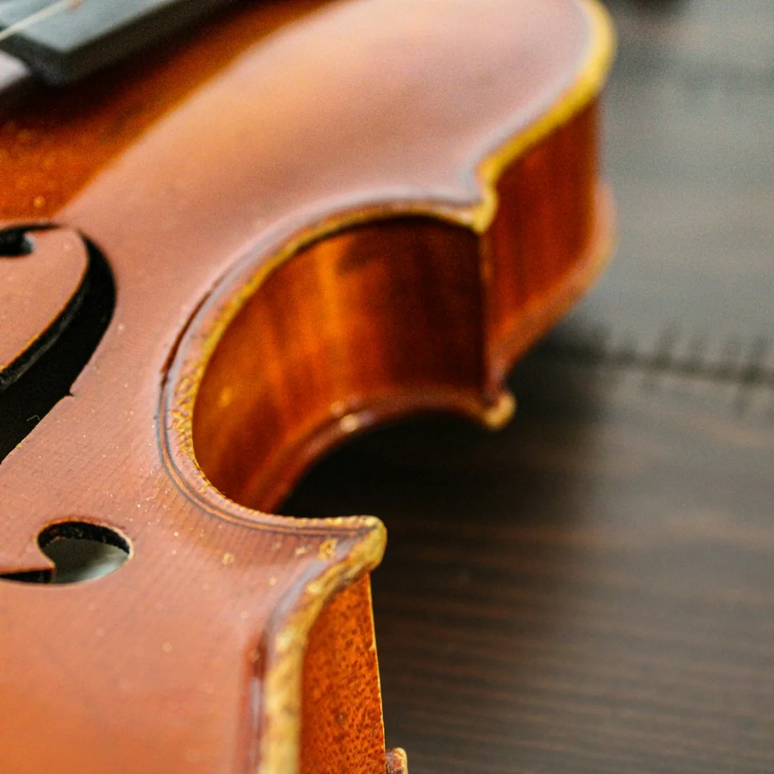 Detalle de la esquina y la efe de un violín, con el filete visible en el borde de la tapa y el aro curvado del ijar.